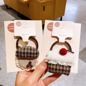 Détail des chouchous faits main avec gland et cupcake pour coiffures d'enfants