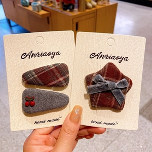 Detailed close-up of plaid fabric hair clips and cherry hairpins on display cards