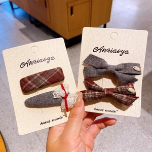 Detailed view of handmade plaid bow hair clips and fabric hairpins on display cards
