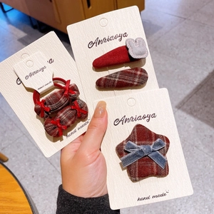 Detail of red plaid fabric hair clips and bow hair ties on display card