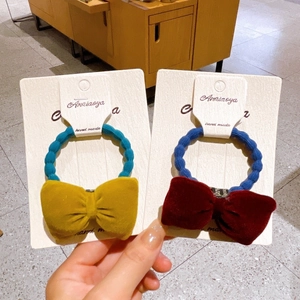 Detail of velvet bow hair ties with elastic cords on branded handmade display card