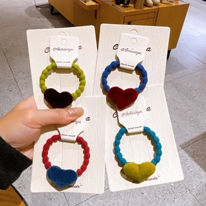 Detailed view of elastic velvet bow hair ties with colorful flocked heart charms on card
