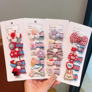 Présentation de lots de barrettes à fleurs et motifs de dessins animés pour filles