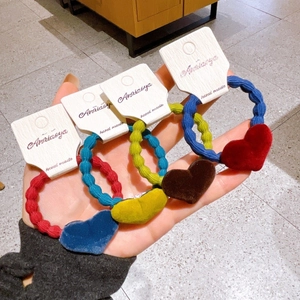 Close-up of four-piece velvet heart hair ties set in red, blue, yellow, and coffee