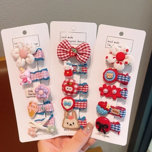 Détail d'un ensemble de barrettes à fleurs et nœuds pour fillettes avec motifs variés