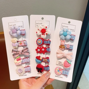 Détail d'un lot de barrettes en tissu avec fleurs et animaux pour fillettes sur cartes