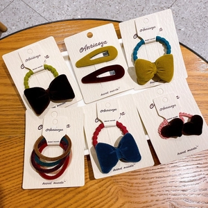 Vintage velvet bow hair ties and elastics set in deep colors on wooden display