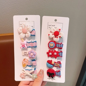 Détail de dix barrettes à cheveux faites main avec fleurs et nœuds sur cartes