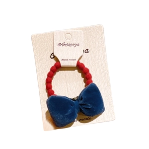 Elegant navy velvet bow hair tie with red elastic band on display card