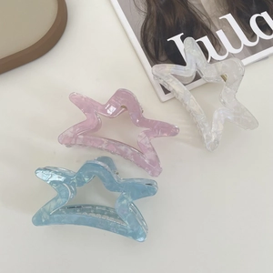 Star-shaped acetate hair claw clips set in pink, light blue, and pearlescent white colors