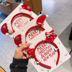 Close-up of festive plush Christmas headbands featuring stars and Santa hats on display