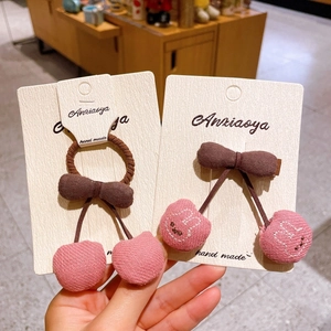 Détail des pinces à cheveux en tissu rose avec broderie lapin et nœuds marron