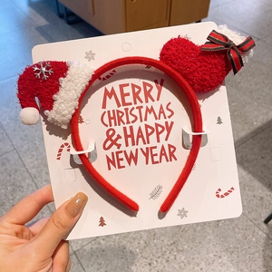 Detail of red plush Christmas headband with snowflake hat and heart on display card