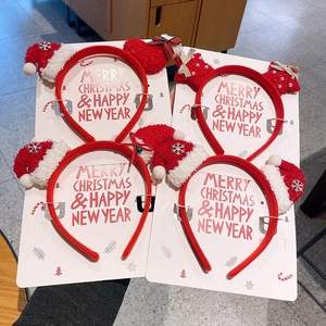 Detail of four festive Christmas headbands with mini hats and plush bows on display