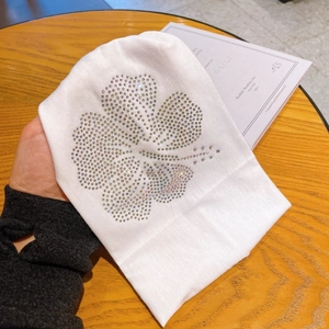 Close-up of white fabric headband with sparkling rhinestone floral pattern decoration