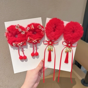 Detail van rode pluche haarstrikken met borduursel, witte bloemen en parelkwastjes