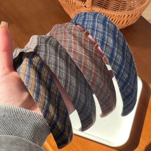 Gros plan de quatre serre-têtes en tweed aux motifs écossais variés pour l'hiver
