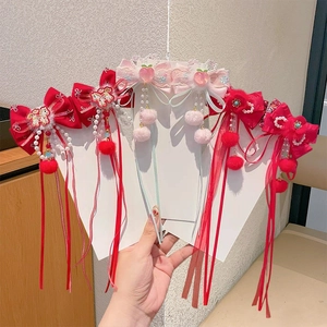 Details von chinesischen Haarspangen in Rot und Rosa mit Stickereien, Perlen und Quasten