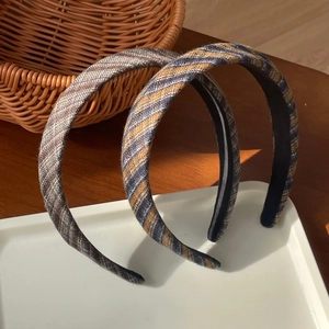 Détail de deux serre-têtes larges en tissu rétro français avec rayures marron et grises