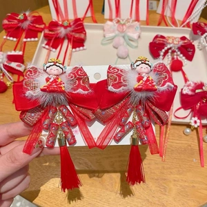 Details von roten Neujahrs-Haarspangen mit Samtquasten und niedlichen Puppenfiguren