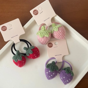 Gros plan d'élastiques à cheveux fraises tricotés en rouge, rose et violet