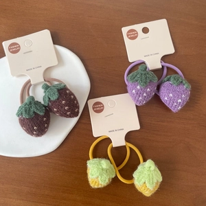 Détail des chouchous fraises au crochet faits main en café, violet et jaune gingembre