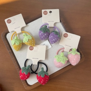 Détail de chouchous fraises tricotés multicolores sur cartes de bijoux mode