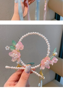 Detail van antieke haarband met parels, roze bloemen van hars en zijden kwastjes
