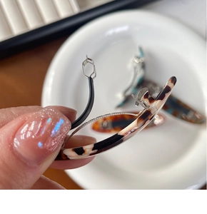 Dettaglio del fermaglio per capelli in acetato tartarugato con meccanismo a molla in metallo