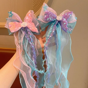 Detail of sequined mermaid tail hair clips with organza ribbons and shell charms
