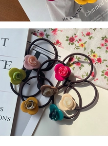 Detail of elegant acetate rose hair ties in various colors on a stylish floral background