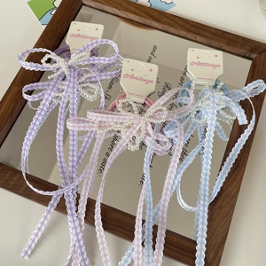 Close-up of pink and purple plaid bow hair clips with pearls and lace ribbon detail