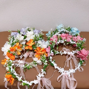 Détail de guirlandes de fleurs artificielles pour filles en orange, rose, blanc et bleu