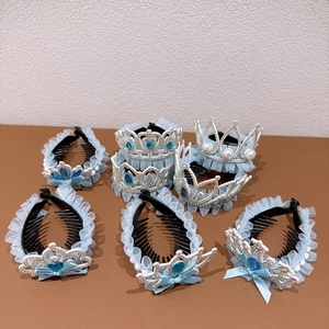 Detail of light blue lace hair clips with silver crown accents, pearls, and blue rhinestones
