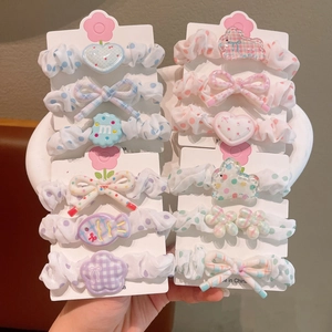 Vue détaillée du lot de 3 chouchous en tissu floral avec des breloques mignonnes