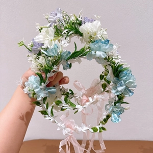 Détail d'un bandeau floral avec fleurs bleues et blanches et ruban en mousseline rose