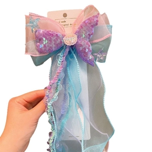 Sparkling mermaid tail hair clip with purple sequins, shell accent, and colorful ribbons