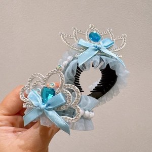 Close-up of a blue princess crown hair clip with lace bow and sparkling blue rhinestones