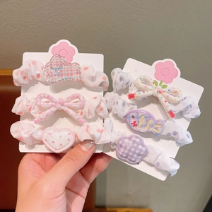 Détail de breloques en résine ours et nœud sur un ensemble de chouchous pour filles