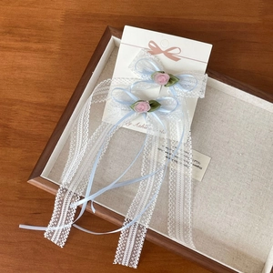 Detalle de pinzas para el cabello de encaje azul con rosas rosas y cintas largas