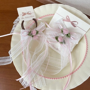 Detalle del pasador de lazo de encaje con rosa rosada y cintas largas elegantes
