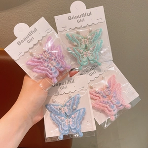 Barrettes papillon brodées avec perles artificielles sur cartes de présentation