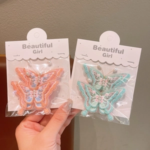 Détail de barrettes papillon brodées en 3D avec perles et glands pour fillettes
