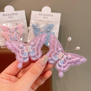 Gros plan de barrettes papillon brodées avec perles et ailes en dentelle pour filles