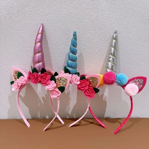 Detailed view of three unicorn headbands with metallic horns and colorful fabric flowers