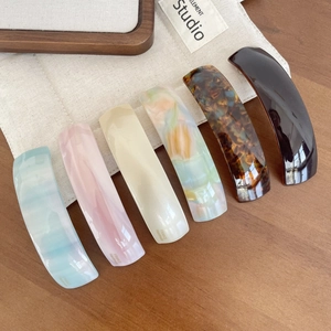 Detail showing various acetate barrettes with marble textures and handmade gold stamps