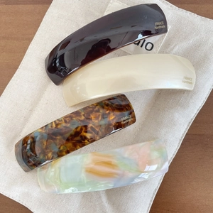 Set of 4 elegant acetate hair clips in tortoiseshell and marble patterns on canvas
