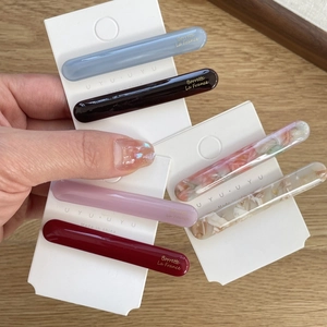 Chic acetate hair clips set in Morandi colors with gold lettering on wooden desk