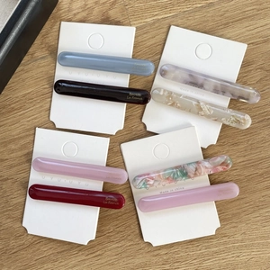 Close-up of eight assorted acetate hair clips with floral patterns on display cards