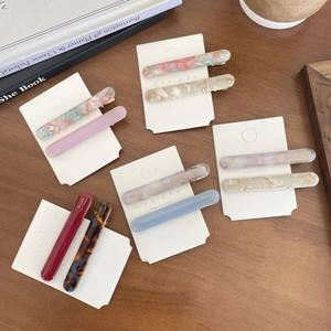 Flat lay of elegant marble and tortoiseshell acetate hair clips on display cards